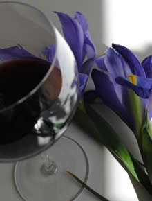 glass of red wine with iris in background